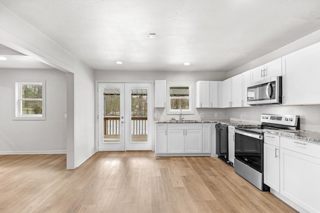 kitchen featuring sink, white cabinets, stainless steel appliances, and light hardwood / wood-style floors