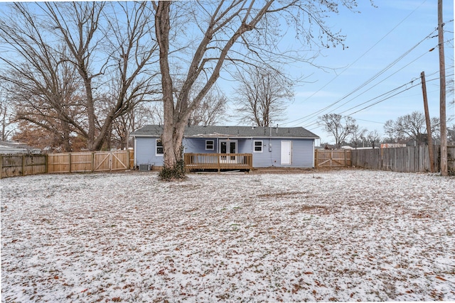 snow covered rear of property featuring a deck