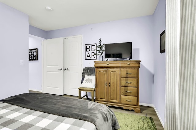 bedroom with dark hardwood / wood-style flooring and a closet