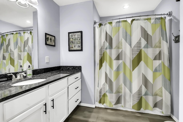 bathroom with curtained shower, vanity, and hardwood / wood-style flooring