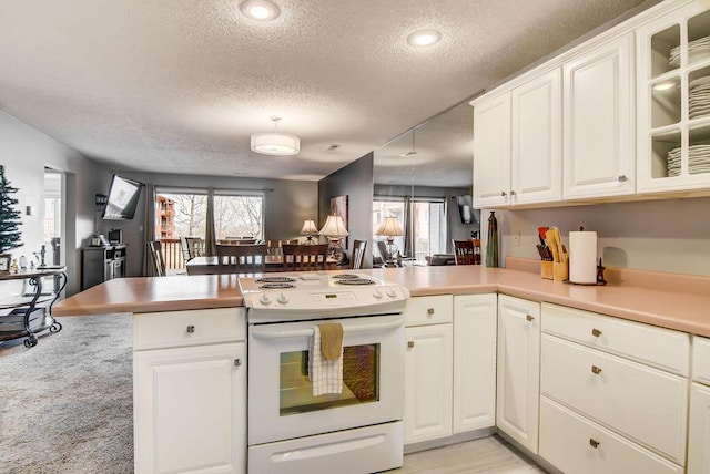 189 Avondale Dr Unit 91-6, Branson, MO 65616 - kitchen with kitchen peninsula, a wealth of natural light, a textured ceiling, electric range, and white cabinets
