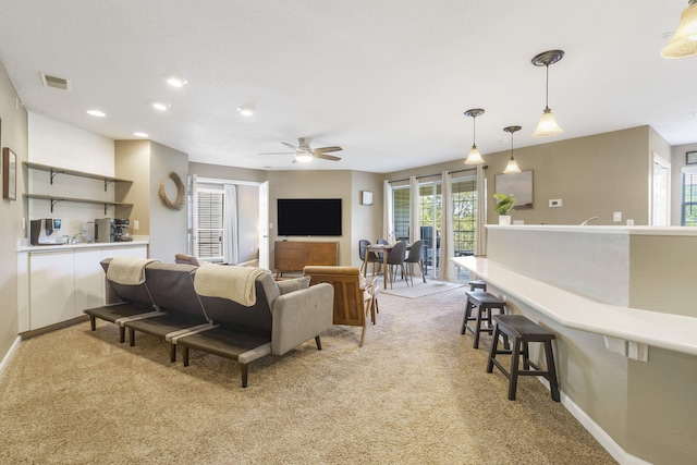 carpeted living room with ceiling fan