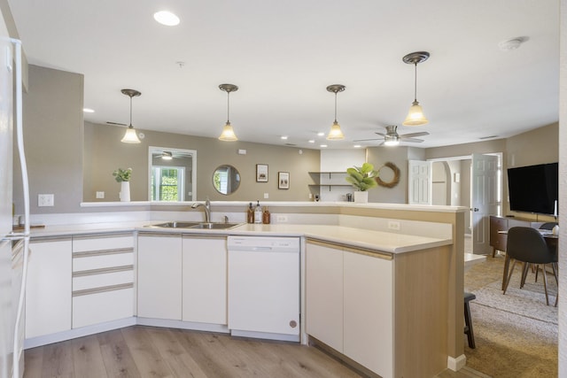 kitchen with dishwasher, decorative light fixtures, white cabinets, and sink