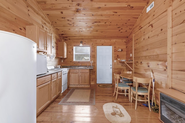 kitchen featuring lofted ceiling, light brown cabinets, and white appliances