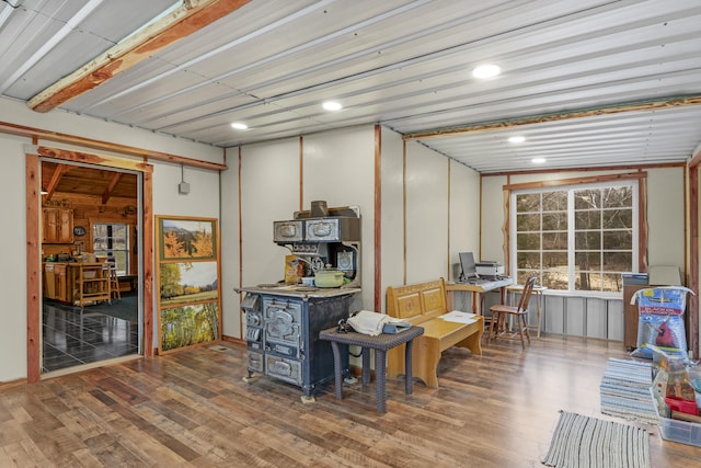 basement featuring wood-type flooring and a wood stove