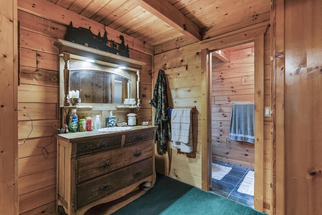 carpeted bedroom featuring beam ceiling, wood walls, and wooden ceiling