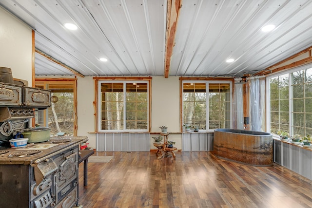 sunroom / solarium featuring beamed ceiling