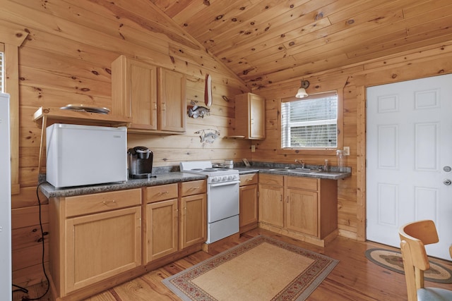 kitchen with lofted ceiling, light wood-type flooring, white gas range, and wooden walls