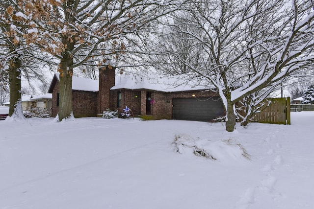 view of snowy exterior featuring a garage