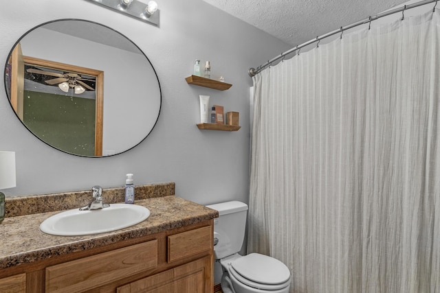 bathroom with vanity, ceiling fan, toilet, a textured ceiling, and walk in shower