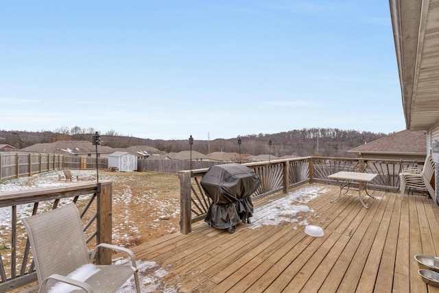 wooden terrace featuring grilling area and a storage unit