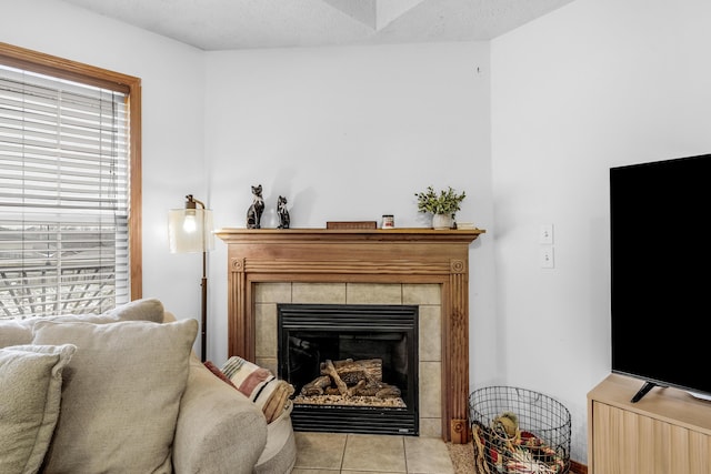 sitting room with light tile patterned floors, a textured ceiling, and a tiled fireplace