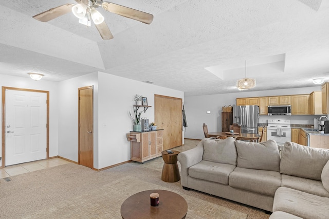 tiled living room with a textured ceiling, ceiling fan, and sink