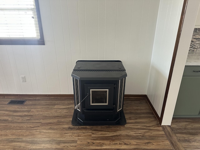 details with a wood stove and hardwood / wood-style floors