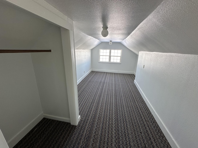 bonus room featuring dark carpet, a textured ceiling, and vaulted ceiling