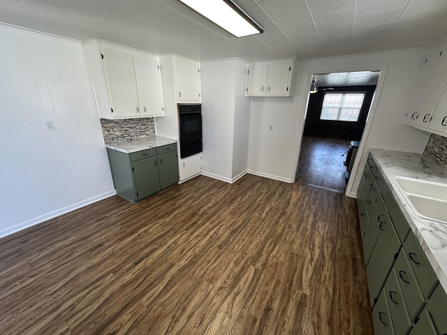 kitchen with sink, green cabinetry, dark hardwood / wood-style floors, black oven, and white cabinetry