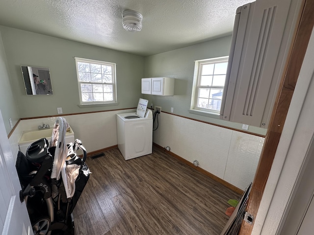 washroom featuring cabinets, a textured ceiling, washer / clothes dryer, and dark hardwood / wood-style floors