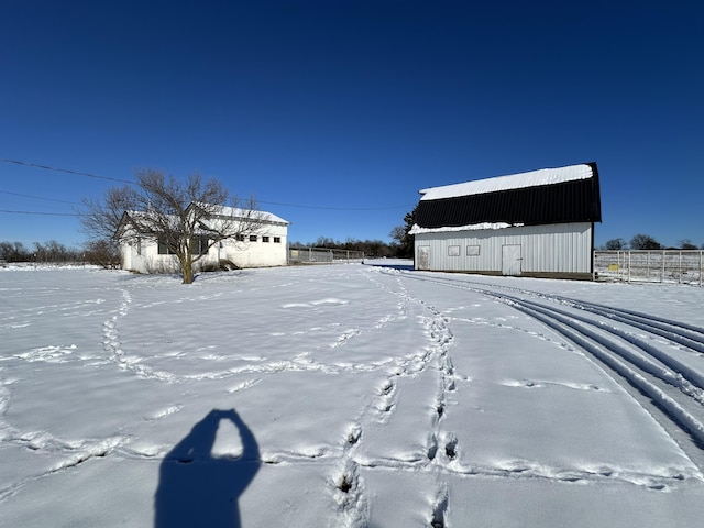 snowy yard featuring an outdoor structure