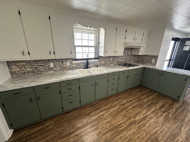 kitchen featuring white cabinets, tasteful backsplash, green cabinets, and sink