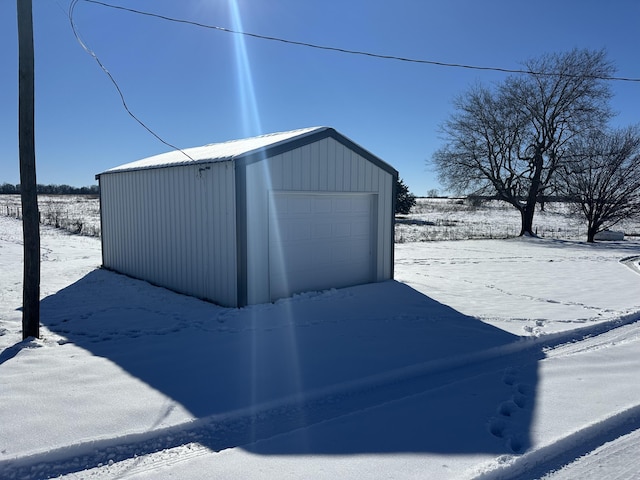 snow covered structure featuring a garage