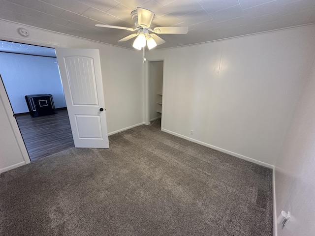 spare room with dark carpet, ceiling fan, and ornamental molding