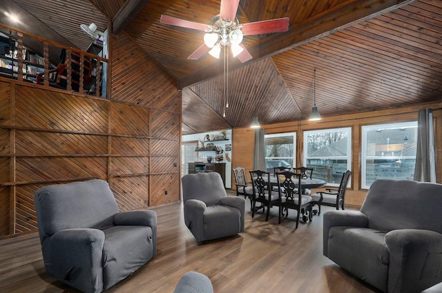 living room with wood walls, ceiling fan, lofted ceiling with beams, and hardwood / wood-style floors