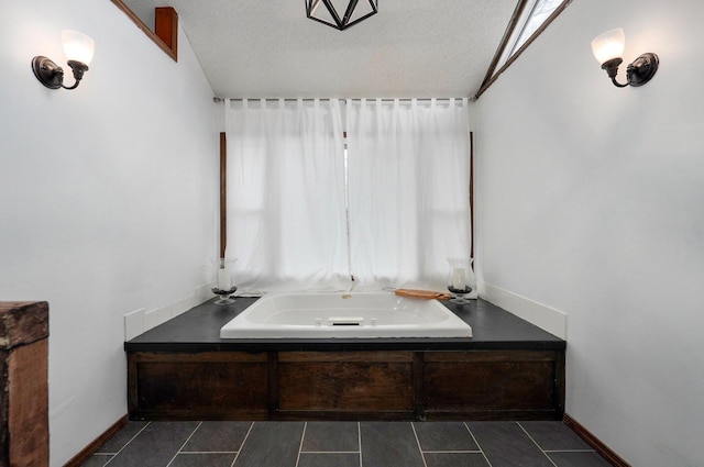 bathroom featuring a washtub and a textured ceiling