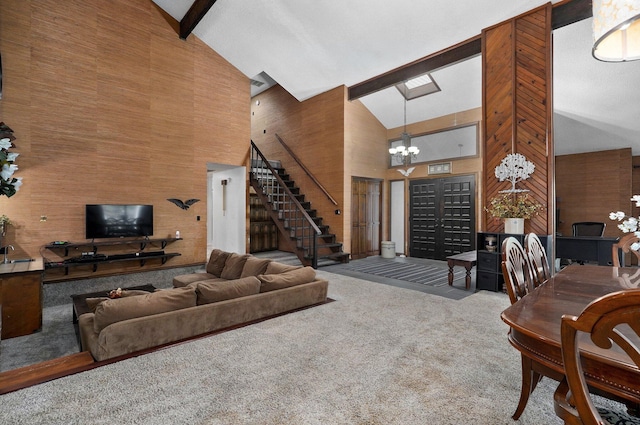 carpeted living room featuring a notable chandelier, high vaulted ceiling, beam ceiling, and wooden walls