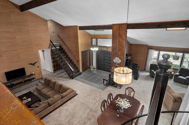 carpeted living room with lofted ceiling with beams and wood walls