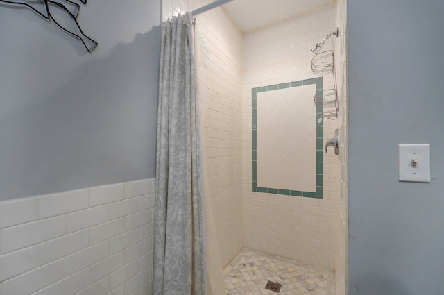 bathroom with tile walls and a shower with shower curtain