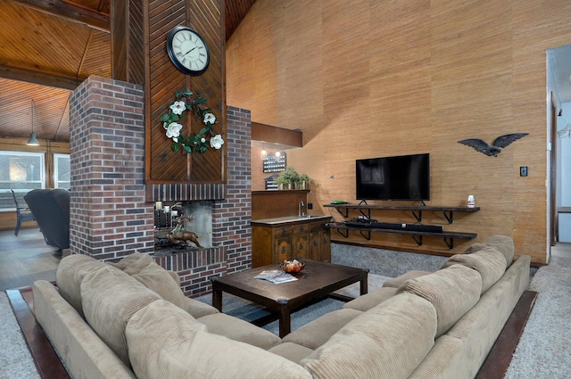 living room with a high ceiling, a brick fireplace, and beamed ceiling