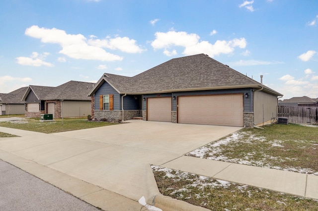 view of front of property with a front lawn, central AC unit, and a garage