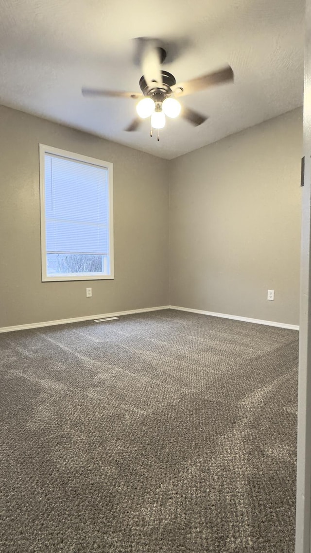 empty room featuring ceiling fan and carpet floors