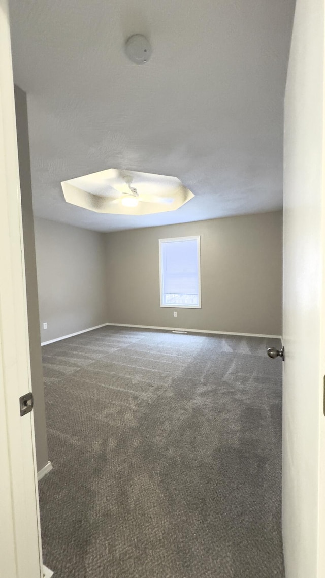 carpeted spare room featuring a tray ceiling