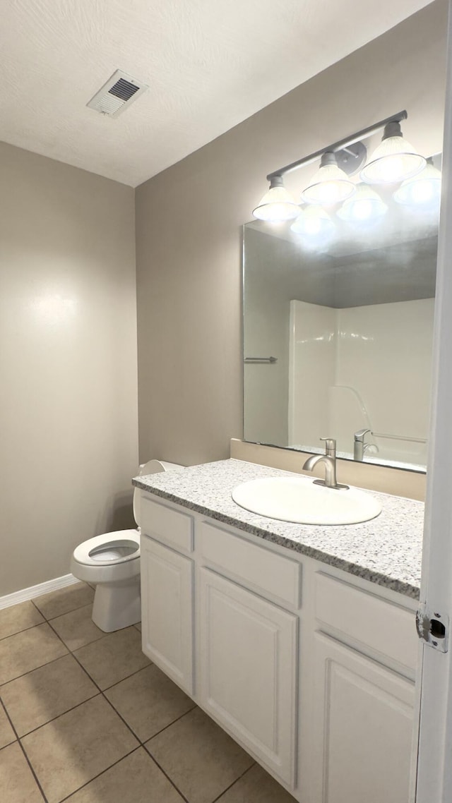 bathroom featuring tile patterned flooring, vanity, and toilet