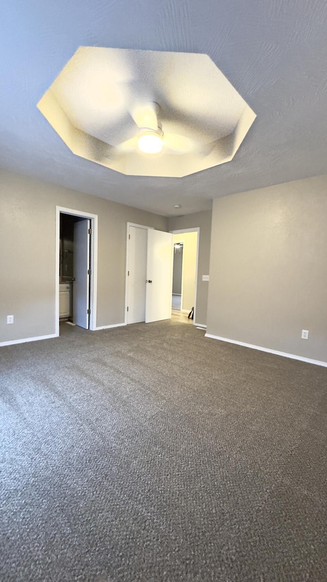 carpeted spare room featuring a raised ceiling