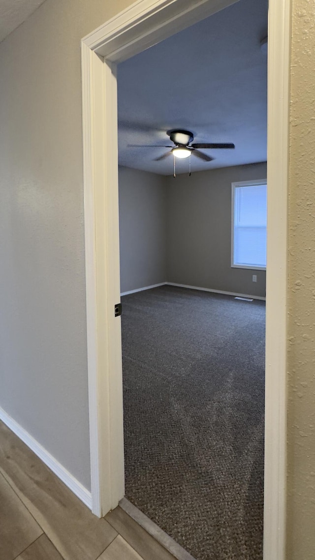 carpeted empty room with ceiling fan