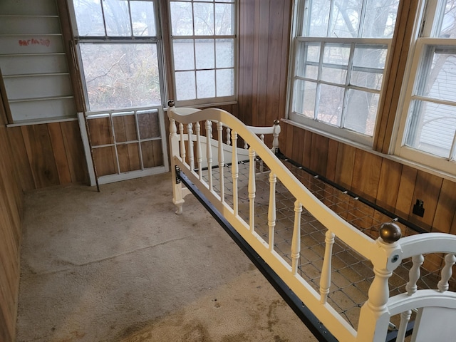 bedroom with carpet and wood walls