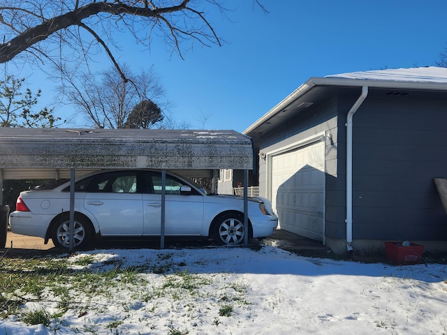 view of snow covered exterior with a garage and a carport