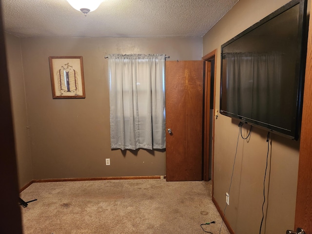 unfurnished bedroom with light carpet and a textured ceiling