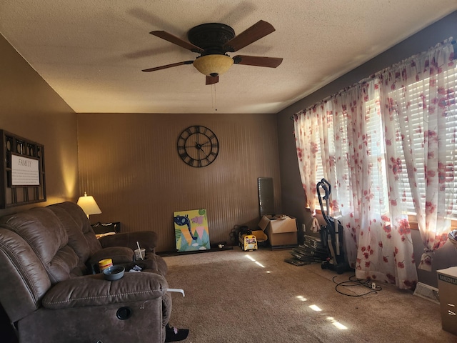 carpeted living room with ceiling fan and a textured ceiling