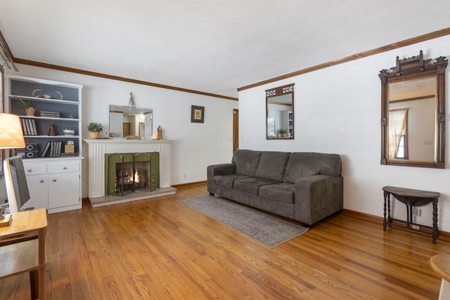 living room with built in features, wood-type flooring, and ornamental molding