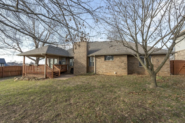 rear view of house with a lawn and a deck