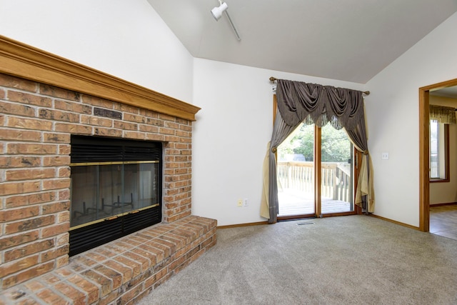 unfurnished living room featuring carpet, lofted ceiling, and a brick fireplace