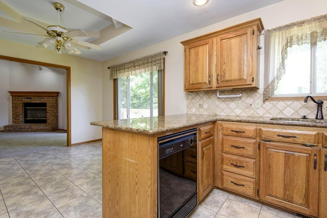 kitchen with sink, a brick fireplace, black dishwasher, backsplash, and kitchen peninsula