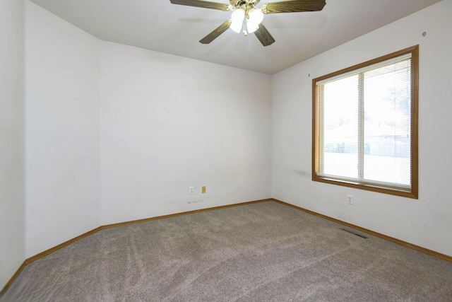 carpeted spare room featuring ceiling fan