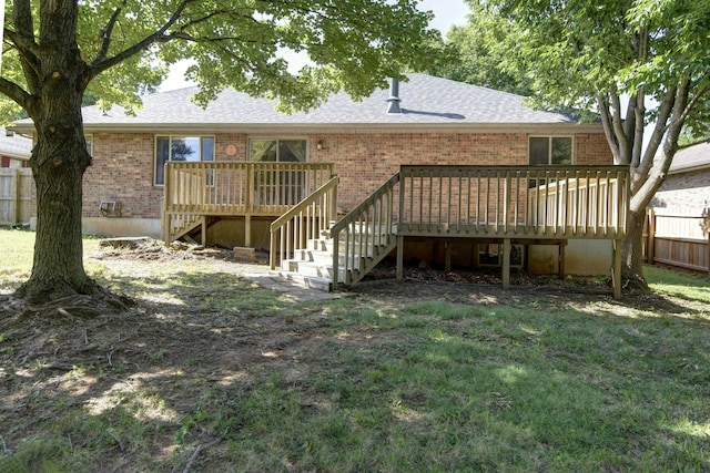 back of property with a yard and a wooden deck