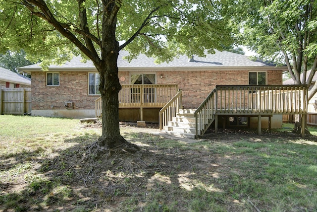 back of property with a lawn and a wooden deck