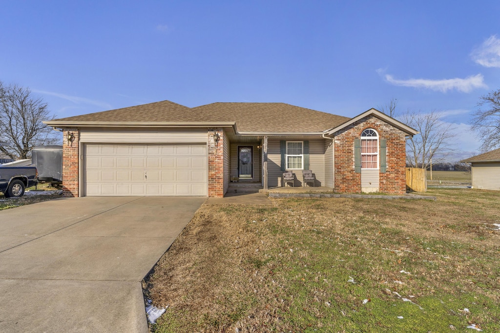 single story home featuring a garage and a front lawn