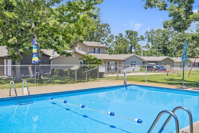 community pool with fence and a lawn